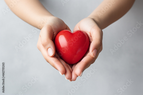 Two hands tenderly holding a vibrant red heart  symbolizing the profound and compassionate connection between individuals in a simple yet powerful gesture of love and care. Ai generated