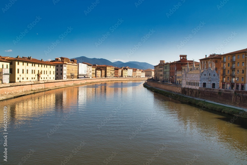 Scenic view of city buildings along the bank of a river in Italy