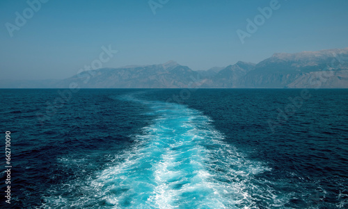 Fototapeta Naklejka Na Ścianę i Meble -  Boat white wake prop wash foam on blue sea background texture. Ripple water spray behind ship. Space