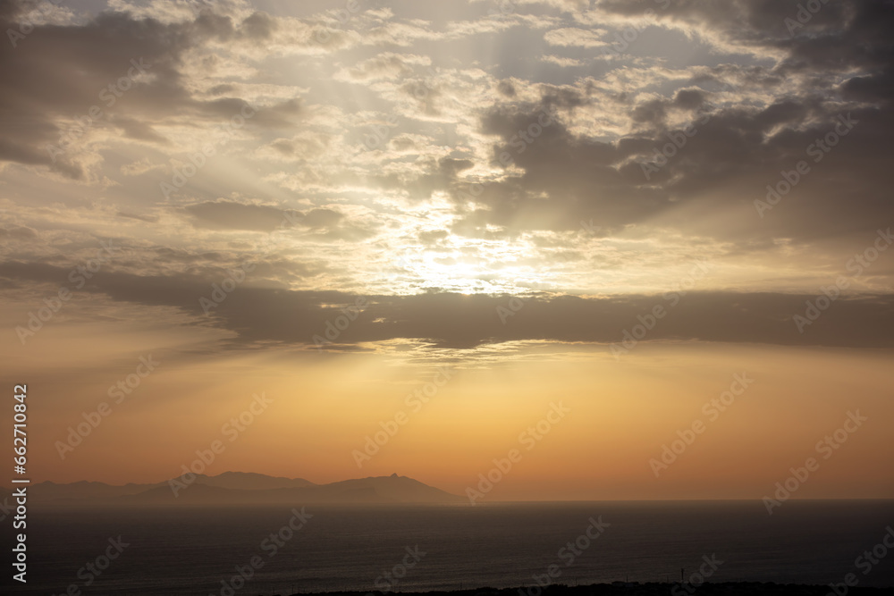 Sunset background. Sunbeam colors the sky, gold sun behind cloud. Ad template for scary movie. Space