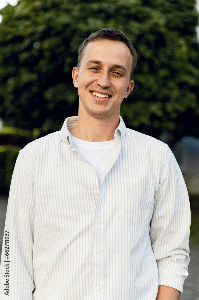 portrait of a satisfied middle-aged man outside. guy in a shirt and jeans smiles portrait of a satisfied middle-aged man outside. guy in a shirt and jeans smiles