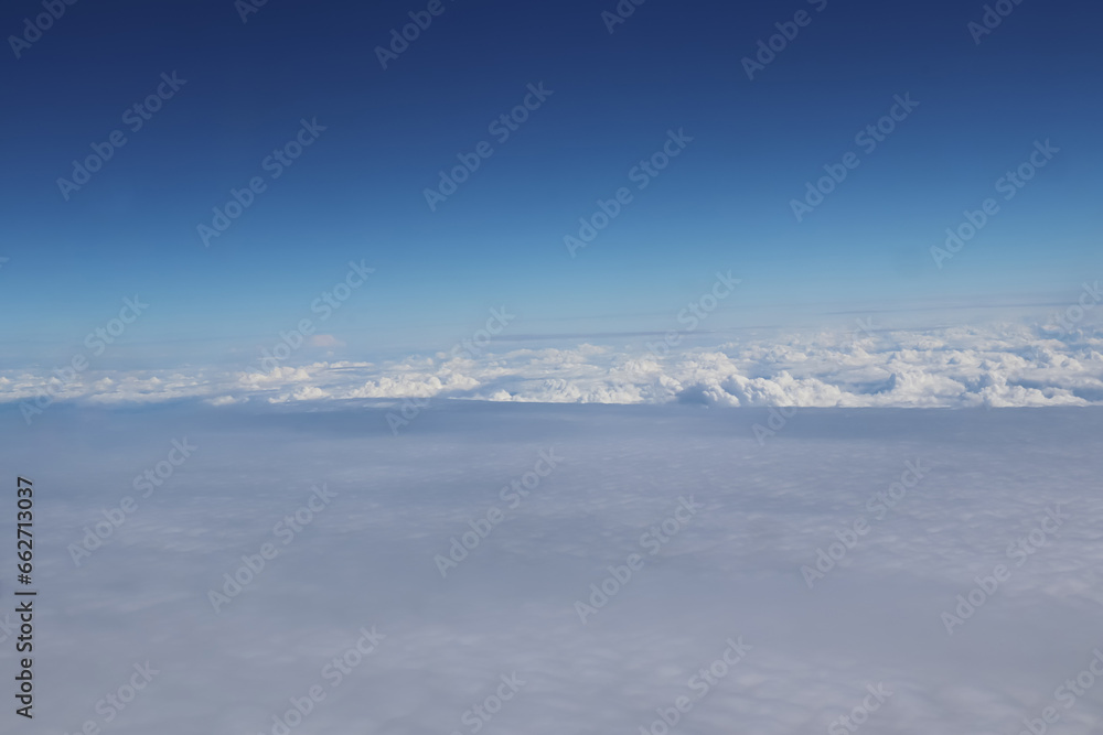Aerial view of massive clouds and beautiful summer blue sky from aircraft window.Image use for environment and meteorology presentation background.