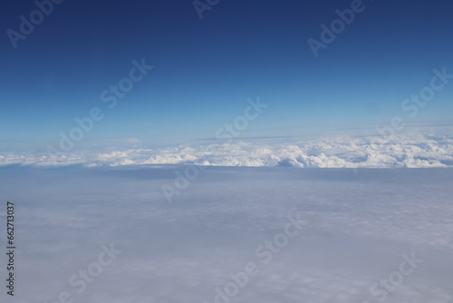 Aerial view of massive clouds and beautiful summer blue sky from aircraft window.Image use for environment and meteorology presentation background.