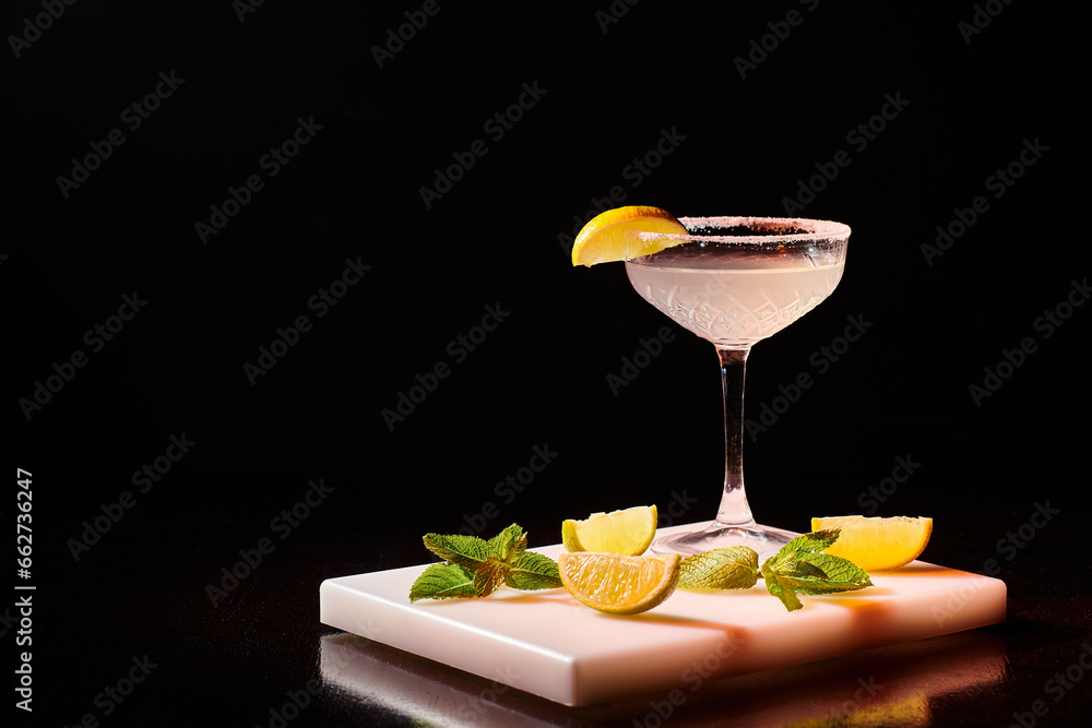 Fotografie ice cold glass of delicious margarita garnished with slice of lime on bar counte