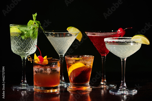 Canvastavla five thirst quenching zesty cocktails with fresh garnishments on black backdrop,