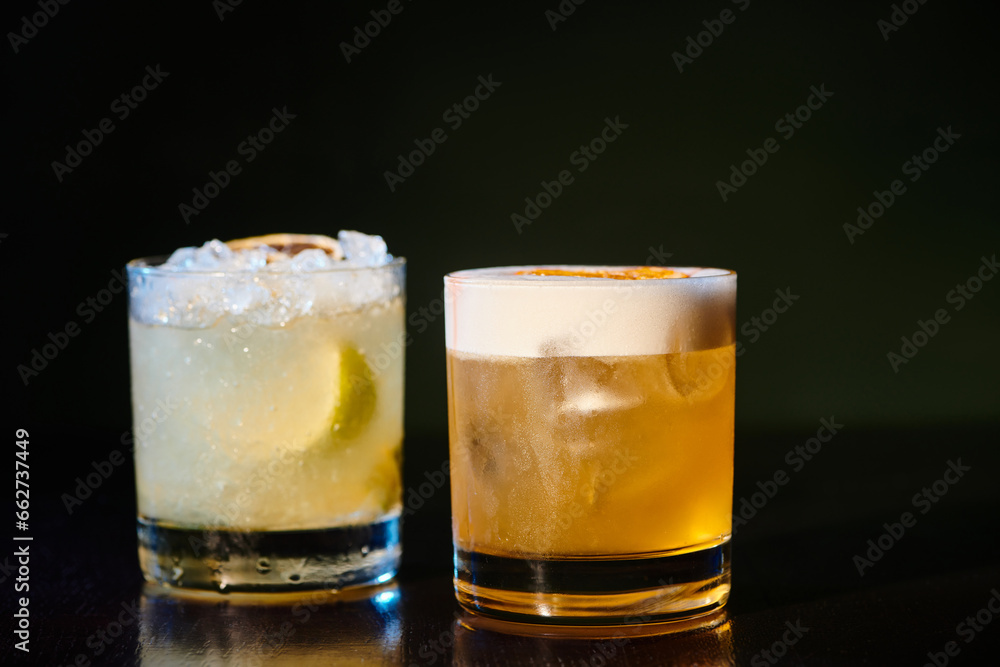 sophisticated whiskey sour and exotic caipirinha on black background, object photo, concept