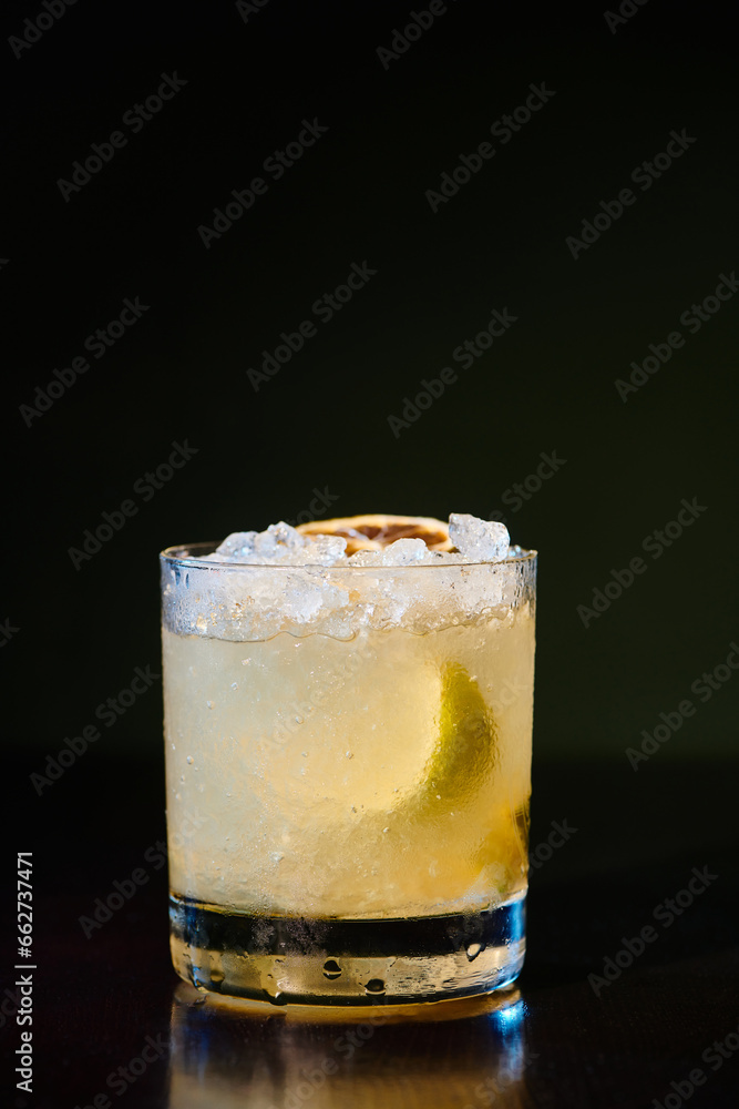 tropical exotic caipirinha with ice and lemon garnishing on black background, concept tropical exotic caipirinha with ice and lemon garnishing on black background, concept