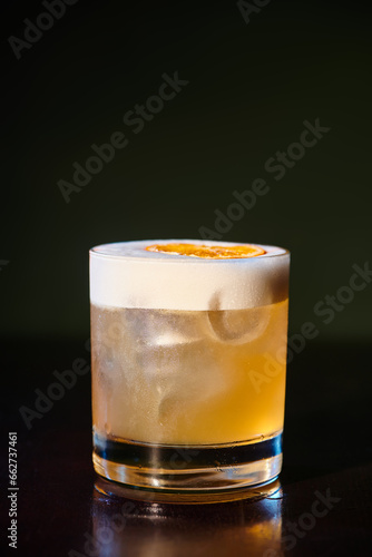 quenching refreshing whiskey sour with delicious frothy foam on black background, concept