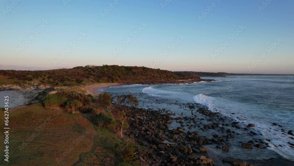 Waves Splashing On Rocky Shore At Sunrise. Angourie Natural Rock Pool Near Spooky Beach In NSW, Australia. aerial Waves Splashing On Rocky Shore At Sunrise. Angourie Natural Rock Pool Near Spooky Beach In NSW, Australia. aerial