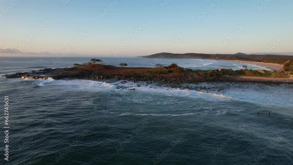 Crashing Waves On Rugged Angourie Point Peninsula With Angourie Point Beach Revealed. New South Wales At Dawn. aerial pan right Crashing Waves On Rugged Angourie Point Peninsula With Angourie Point Beach Revealed. New South Wales At Dawn. aerial pan right