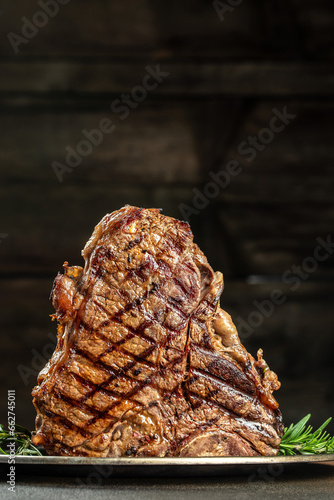 T-bone grilled beef steak with spices on a dark background. Restaurant menu, dieting, cookbook recipe