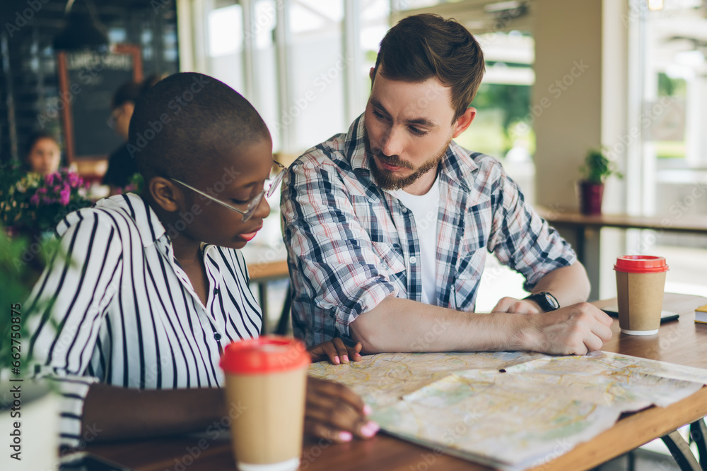 Couple preparing for trip with map in cafe Couple preparing for trip with map in cafe