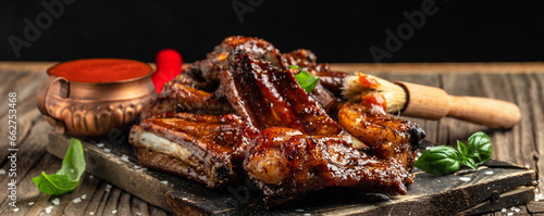 pork ribs grilled with BBQ sauce on a wooden board. Healthy fats, clean eating for weight loss. Long banner format. top view