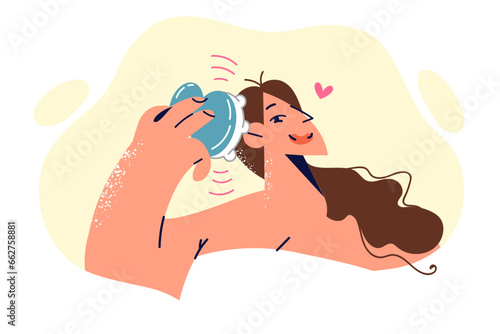 Woman uses head massager after getting out of shower to relieve cranial pressure and stress