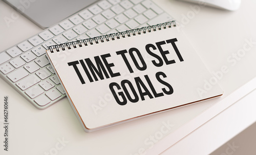 TIME TO SET GOALS text written on a notebook on grey background with chart and keyboard , business concept