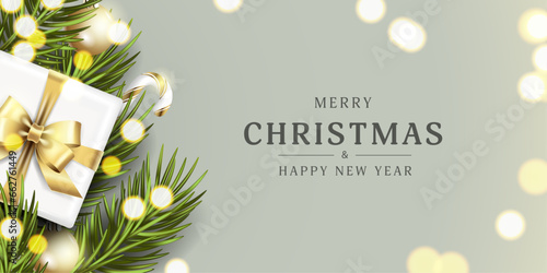 Realistic Christmas card on a gray background with fir green branches, golden Christmas tree decorations and a gift with a gold bow around glitter for the New Year holiday. Vector illustration.