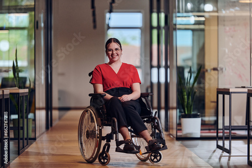 A modern young businesswoman in a wheelchair is surrounded by an inclusive workspace with glass-walled offices, embodying determination and innovation in the business world