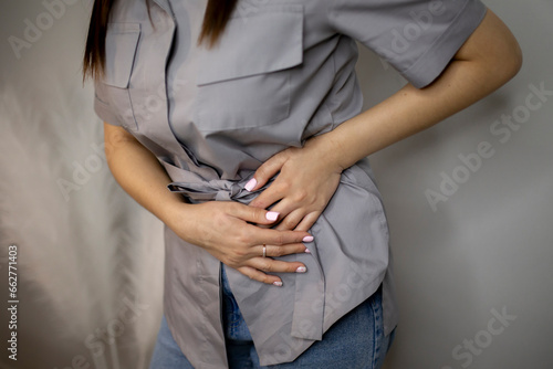 woman holding her stomach and feeling awful stomach ache