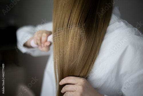 a young girl combing her long hair close up shot