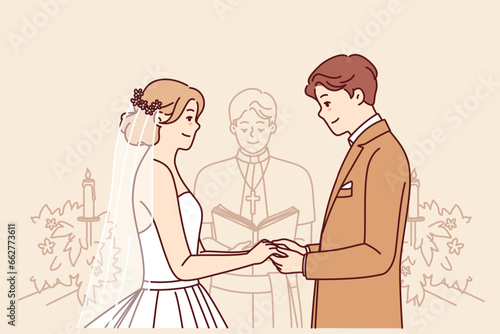 Bride and groom on altar, hold hands and listen to speech of priest during wedding ceremony in church. Wedding ceremony with man and woman, want to create new family for living together