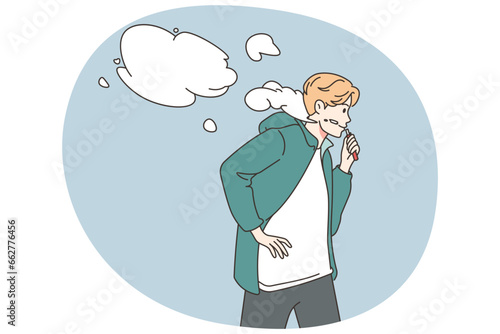 Young man smoking vaper outdoors