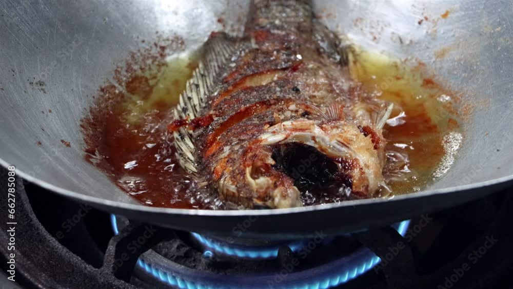 Tilapia fish is fried in oil in a pan Tilapia fish is fried in oil in a pan