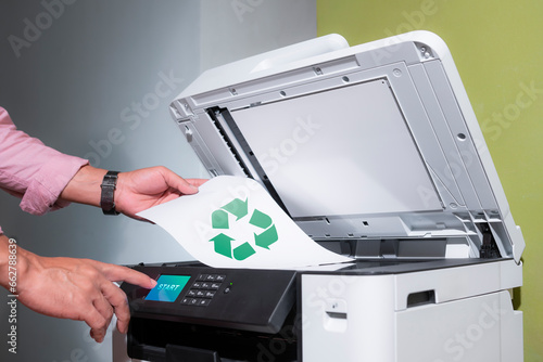 Obraz na plátně office worker prints paper on a multifunction laser printer with recycled paper in home office documents or paperwork