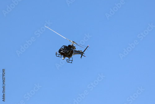A helicopter crosses the blue sky with clouds. Transportation. Urban.