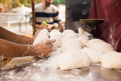 Men's hands knead yeast dough for baking bread