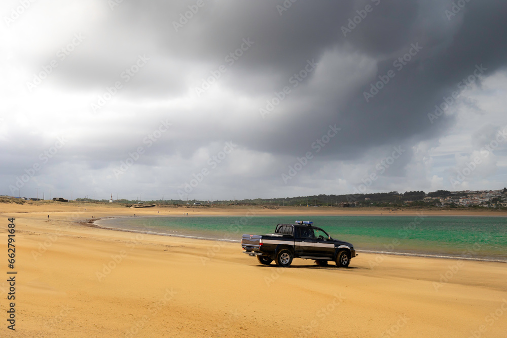 Truck on the sand with stormy skies, in the beach of Sao Martinho do Porto - Portugal Truck on the sand with stormy skies, in the beach of Sao Martinho do Porto - Portugal