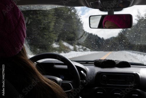 Woman driving a car on a winter landscape