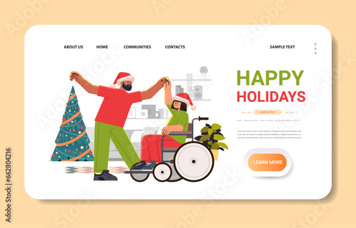 disabled woman in santa claus hat sitting in wheelchair and dancing with man people with disabilities concept merry christmas holidays celebration