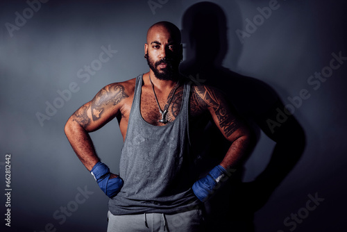 Muscular black man with bandages on his hands looks at camera in determined attitude