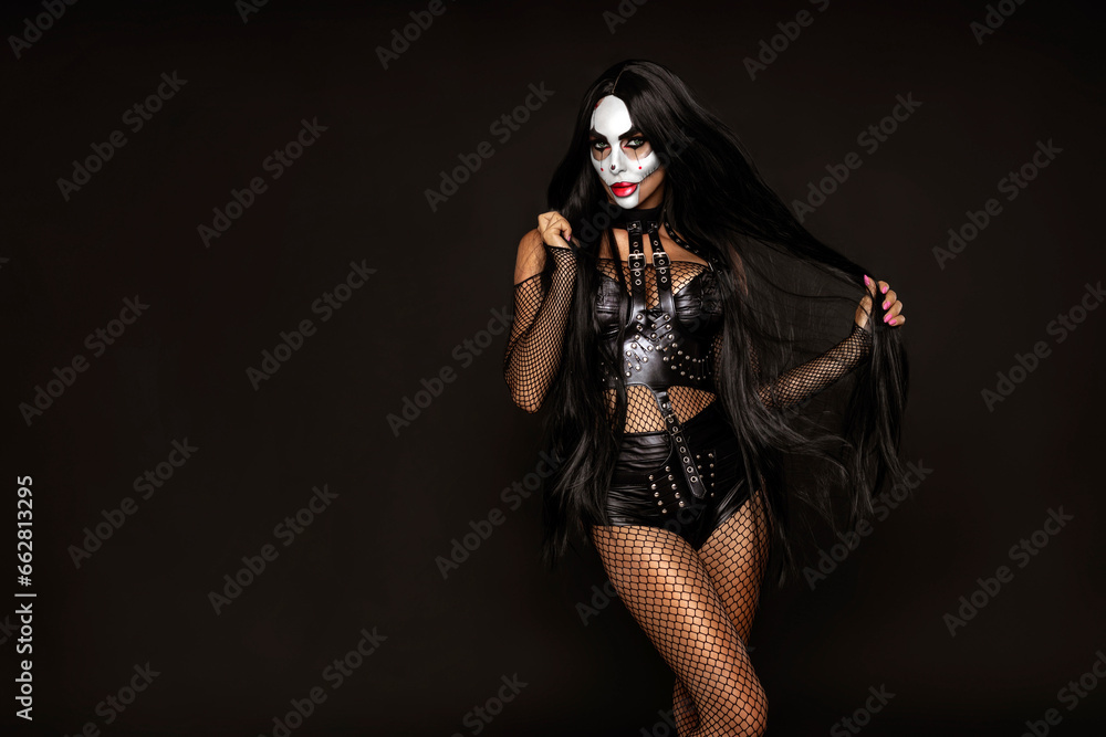 Sexy woman in a Halloween makeup and latex costume on black background. Halloween makeup and costume concept. Sexy woman in a Halloween makeup and latex costume on black background. Halloween makeup and costume concept.