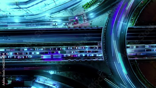 Financial technology, energy power, beautiful top view time-lapse of car traffic at roundabout lane and buildings. 4K drone aerial zoom out. Urban cityscape concept or abstract of advanced innovation.