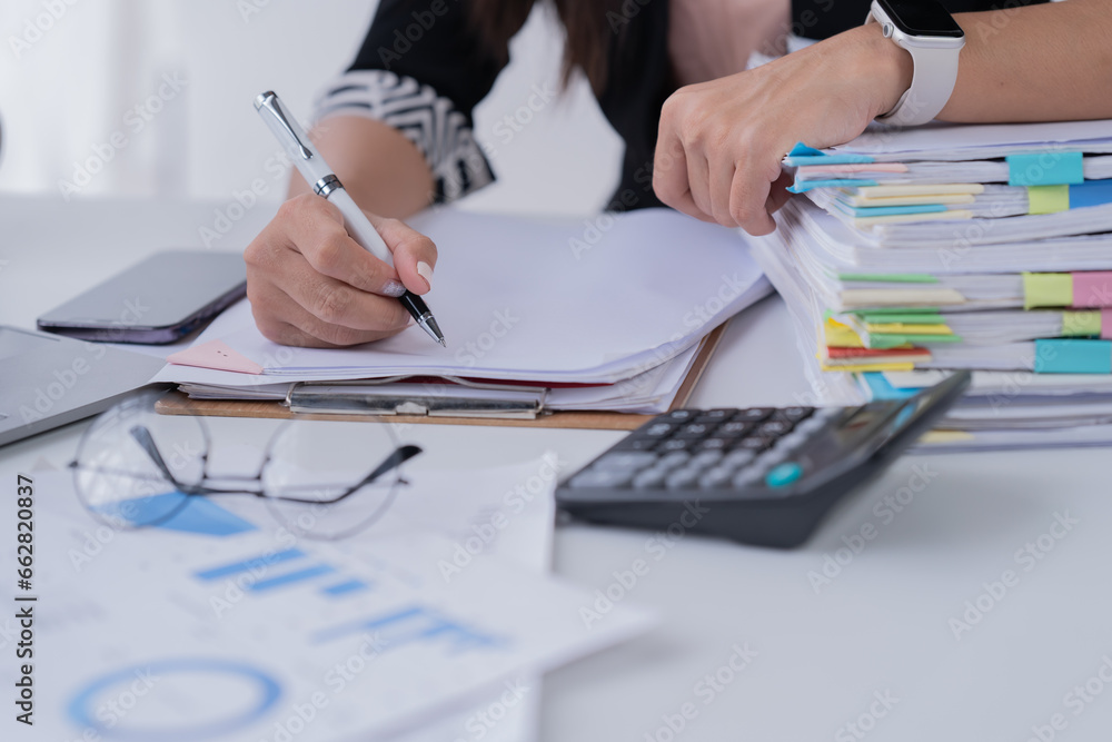 Naklejka premium Business Documents concept : Employee woman hands working in Stacks paper files for searching and checking unfinished