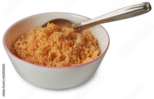 coconut sambol or pol sambol in white bowl with a spoon, popular traditional and delicious condiment made from freshly grated coconut mixed with chili flakes, isolated on white background