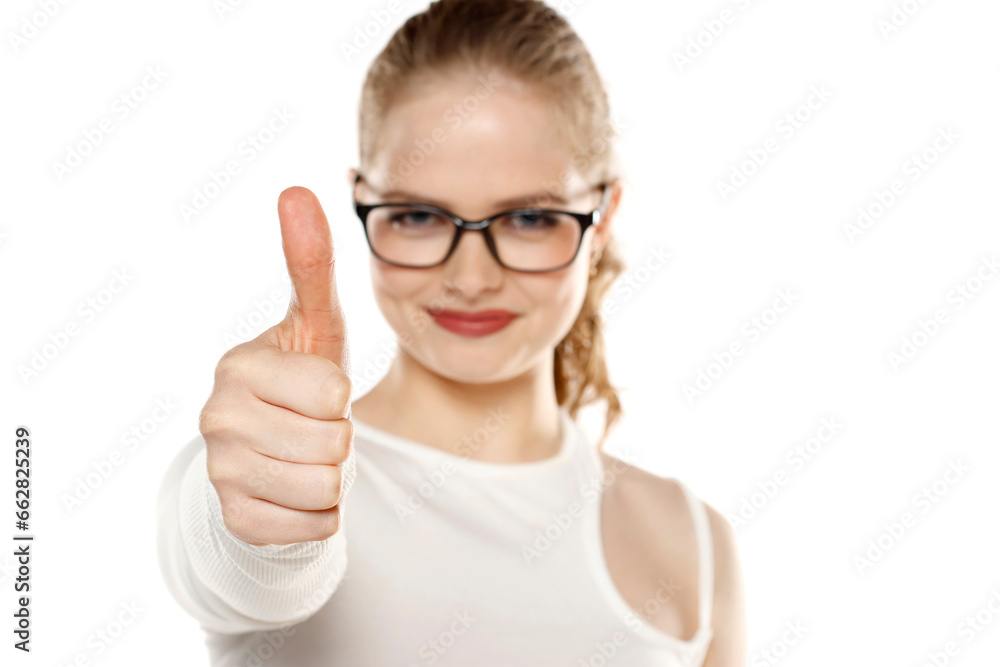 Smiling woman with glasses showing thumb up on a white background Smiling woman with glasses showing thumb up on a white background