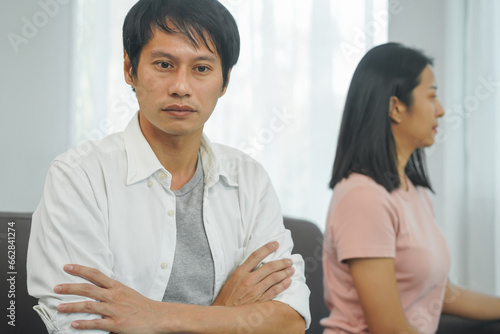 woman sitting back to back to his husband after quarrel at home