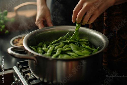 Close Up Shot Of Woman Hands Adding Edamame To The Pot In The Kitchen