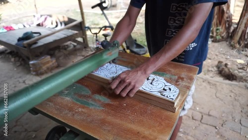 The initial process of making traditional Javanese Gebyok is made from whole wood which is cut and carved using simple tools by wood craftsmen. photo