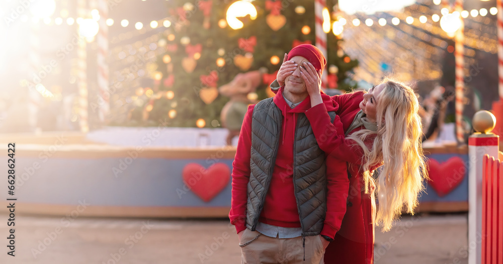 Happy caucasian couple in love on romantic date walking city streets Christmas fair time over light bokeh. Pastime together. Romantic, love family and greeting concept New Year winter. Copy space