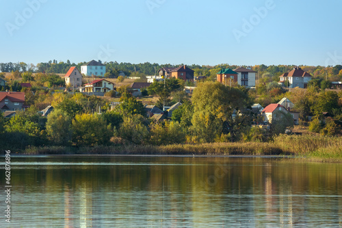 Village on the shore of a lake in Ukraine on an autumn sunny day