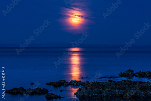 The super moon (a blue moon) on 30/8/2023 rising over the Isle of Arran seen from the Kintyre Peninsula, Scotland UK