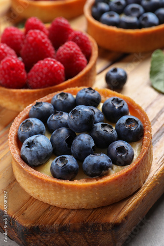 Tartlet with fresh blueberries on wooden board. Delicious dessert