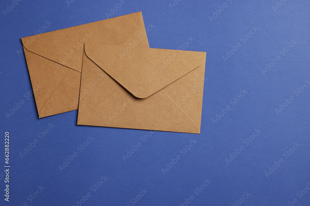 Envelopes made of parchment paper on blue background, flat lay. Space for text Envelopes made of parchment paper on blue background, flat lay. Space for text