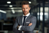 Confident businessman standing arms crossed in office 