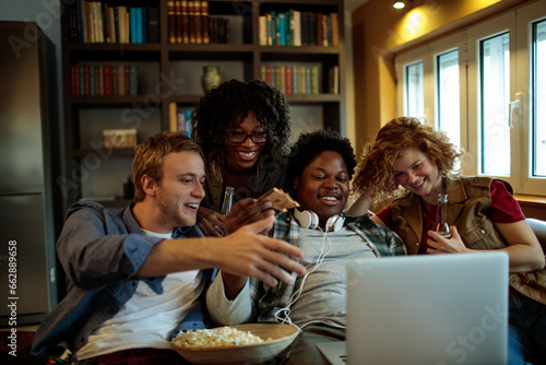 Young and diverse group of friends watching a movie together on the laptop at home