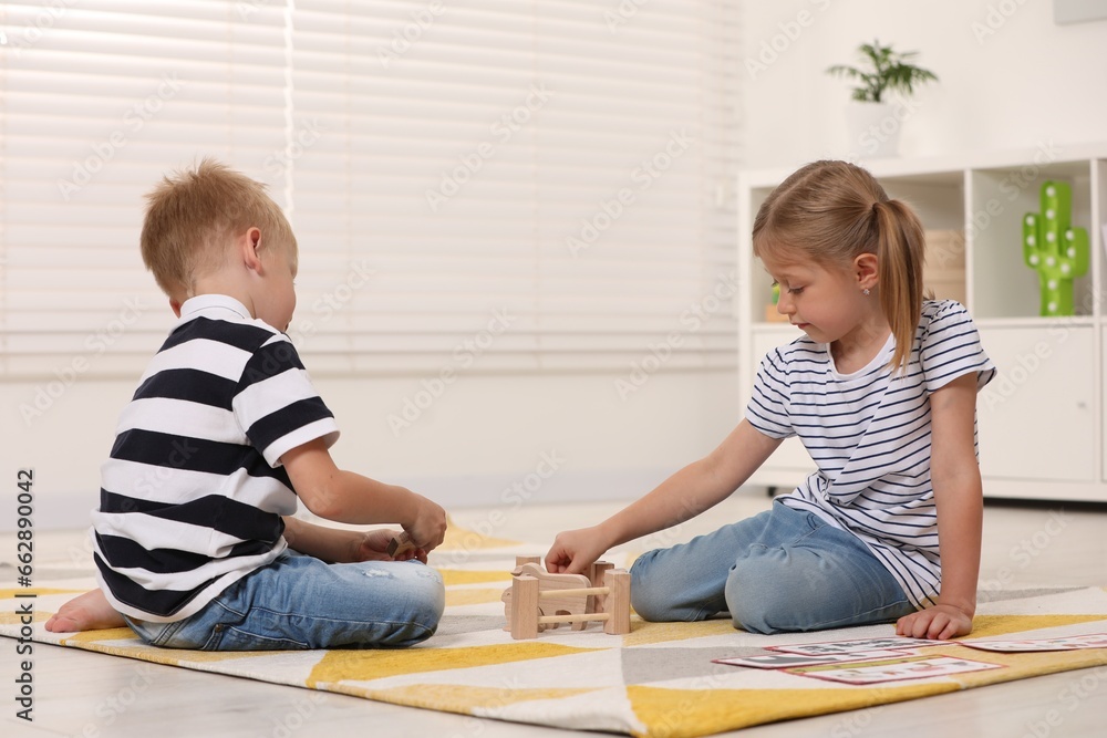 Little boy and girl playing with set of wooden animals indoors. Children's toys Little boy and girl playing with set of wooden animals indoors. Children's toys