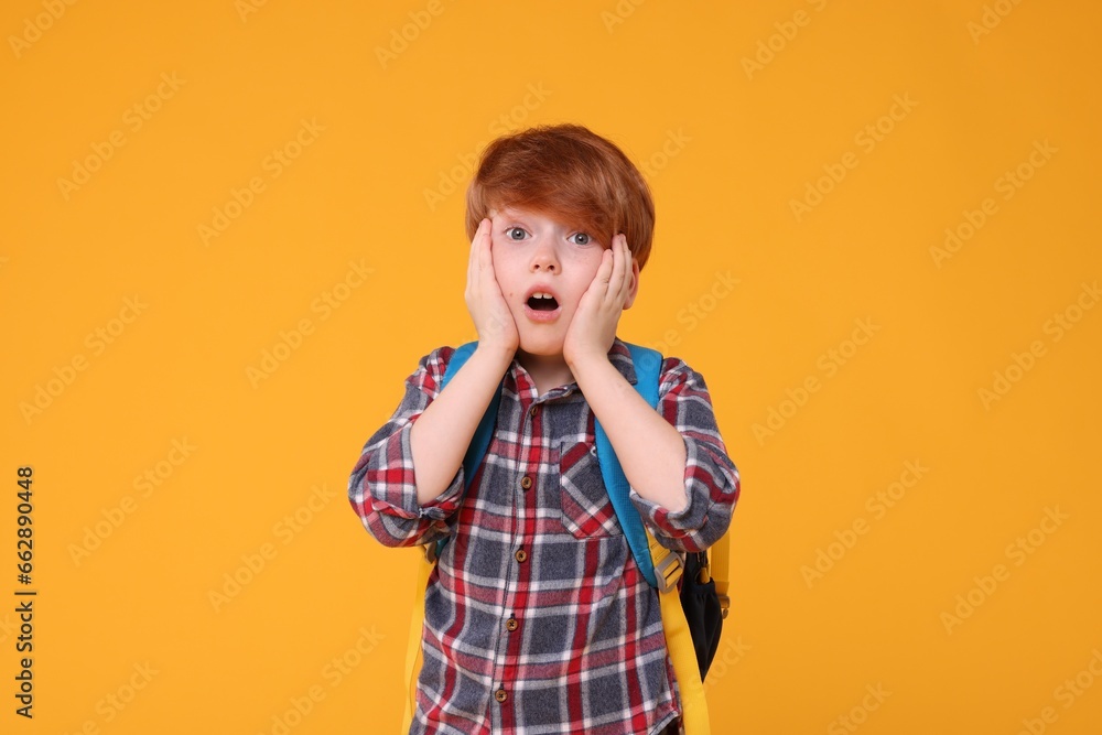 Portrait of emotional schoolboy on orange background Portrait of emotional schoolboy on orange background